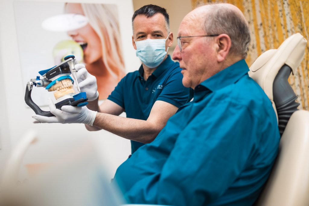 Zahnersatz - Patient und Dr. Seiss mit Artikulator